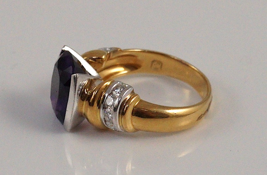 A modern 18ct gold and single stone cushion cut amethyst set dress ring, with ten stone diamond set shoulders